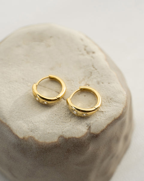 the hexad signature hoop earrings now feature petite dahlia flower designs with tiny diamand stones for a touch of sparkle