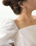 Minimal gold hoop drop earrings worn as a stud - The Hexad