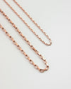 close up detailing of the parallel chain necklaces in rold gold hue from the hexad
