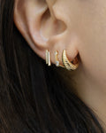 close up of The Hexad ear stack comprising Capri vintage hoop, Pixie huggie hoop and Double Bar stud earring in gold