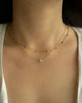 dainty minimal neck stack style featuring solitaire pendant necklace and whimsical chain in gold