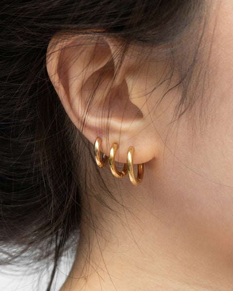 essential huggie hoop earrings in gold plated titanium steel designed in 3 sizes