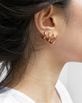 multiple piercings look styled with uki huggie earrings in rose gold from the hexad
