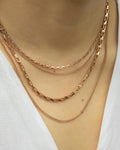 multiple rose gold chain necklaces layered in differing lengths for low cut necklines