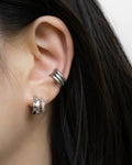 silver atlantis illusion earrings layered with a triple conch stack of retractable hoops by the hexad