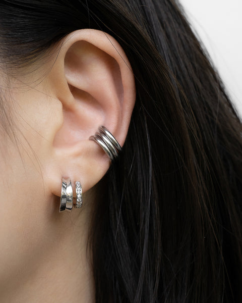 silver atlantis illusion earrings layered with a triple conch stack of retractable hoops by the hexad