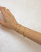 sleek gold chain reptile bracelets as worn on model's wrist
