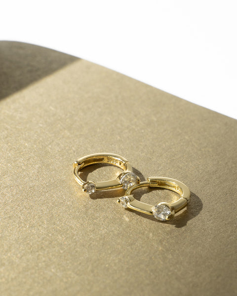 snug huggie hoop earrings in gold with tiny zirconia stones by the hexad