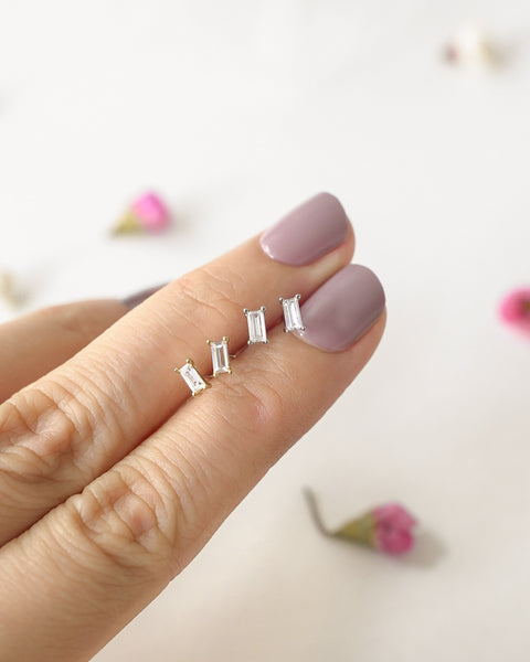 teeny tiny baguette cut diamond ear studs in gold and silver by the hexad
