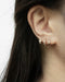 tiny rose gold hoop earrings that hug your lobes for a chic understated look suitable for everyday
